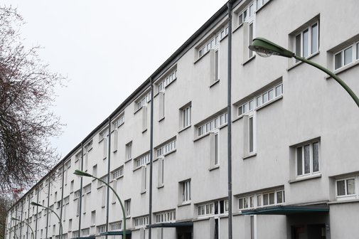 Ein weiß angestrichener Wohnblock mit drei Stockwerken